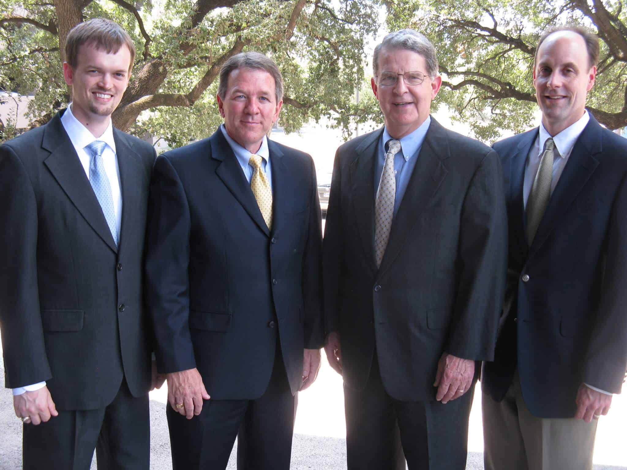 Experienced family law attorneys from Bray, Chappell, Patterson, and Olsen standing outdoors, dressed in professional business suits.